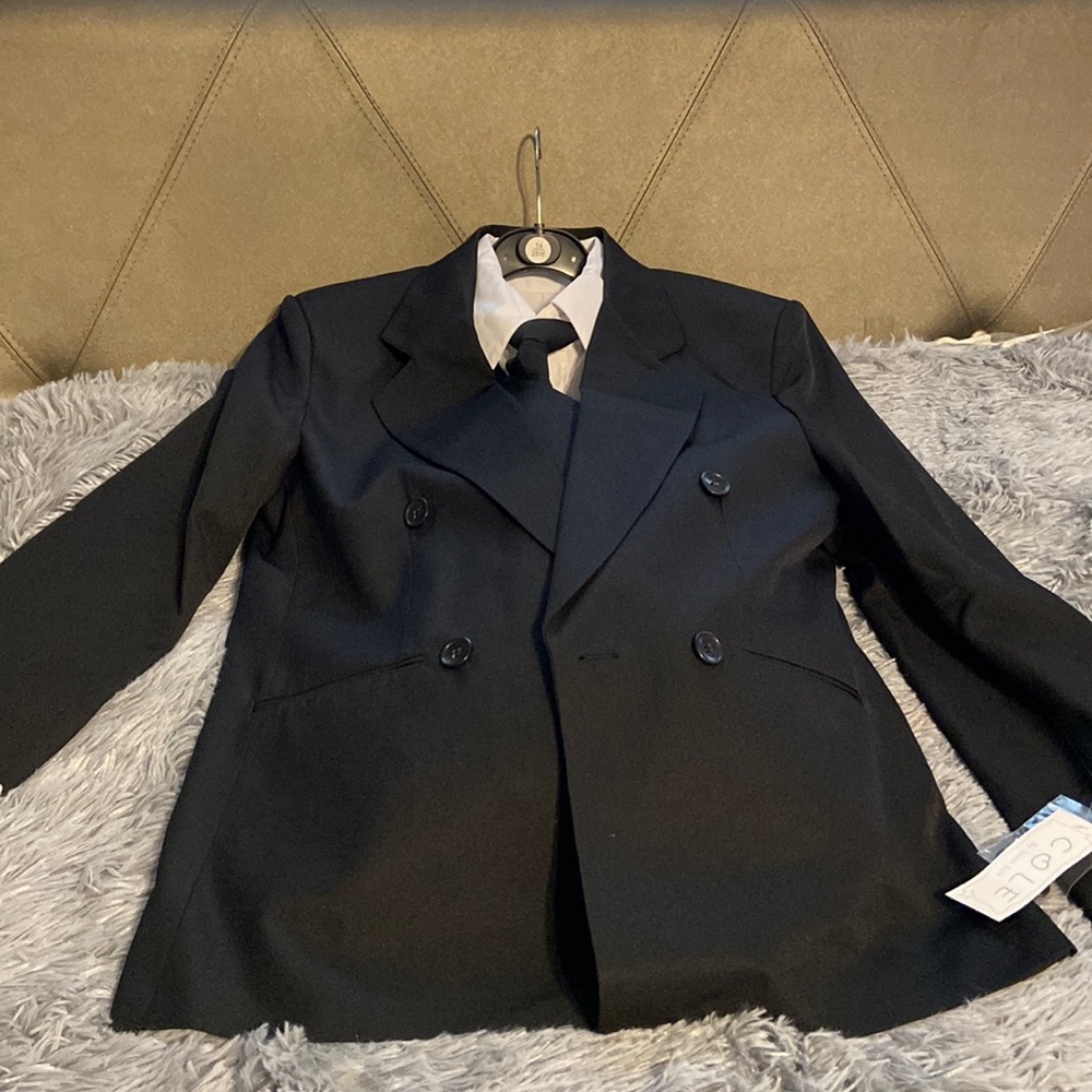 Brand new black suit with white shirt, black vest, and pants and tie.